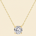 Gold necklace with a clear gemstone pendant on a white background