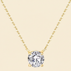 Gold necklace with a clear gemstone pendant on a white background