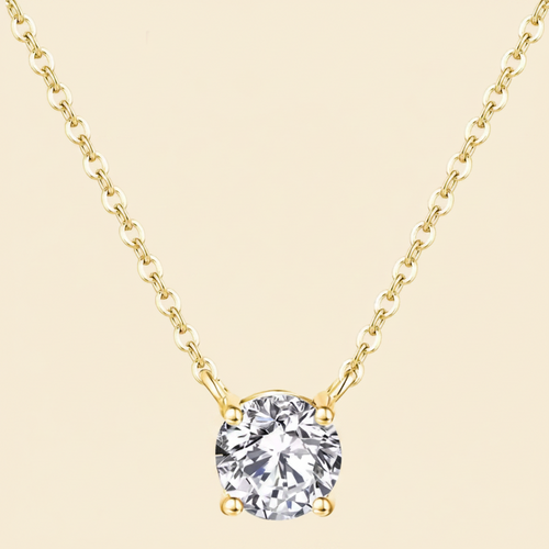 Gold necklace with a clear gemstone pendant on a white background